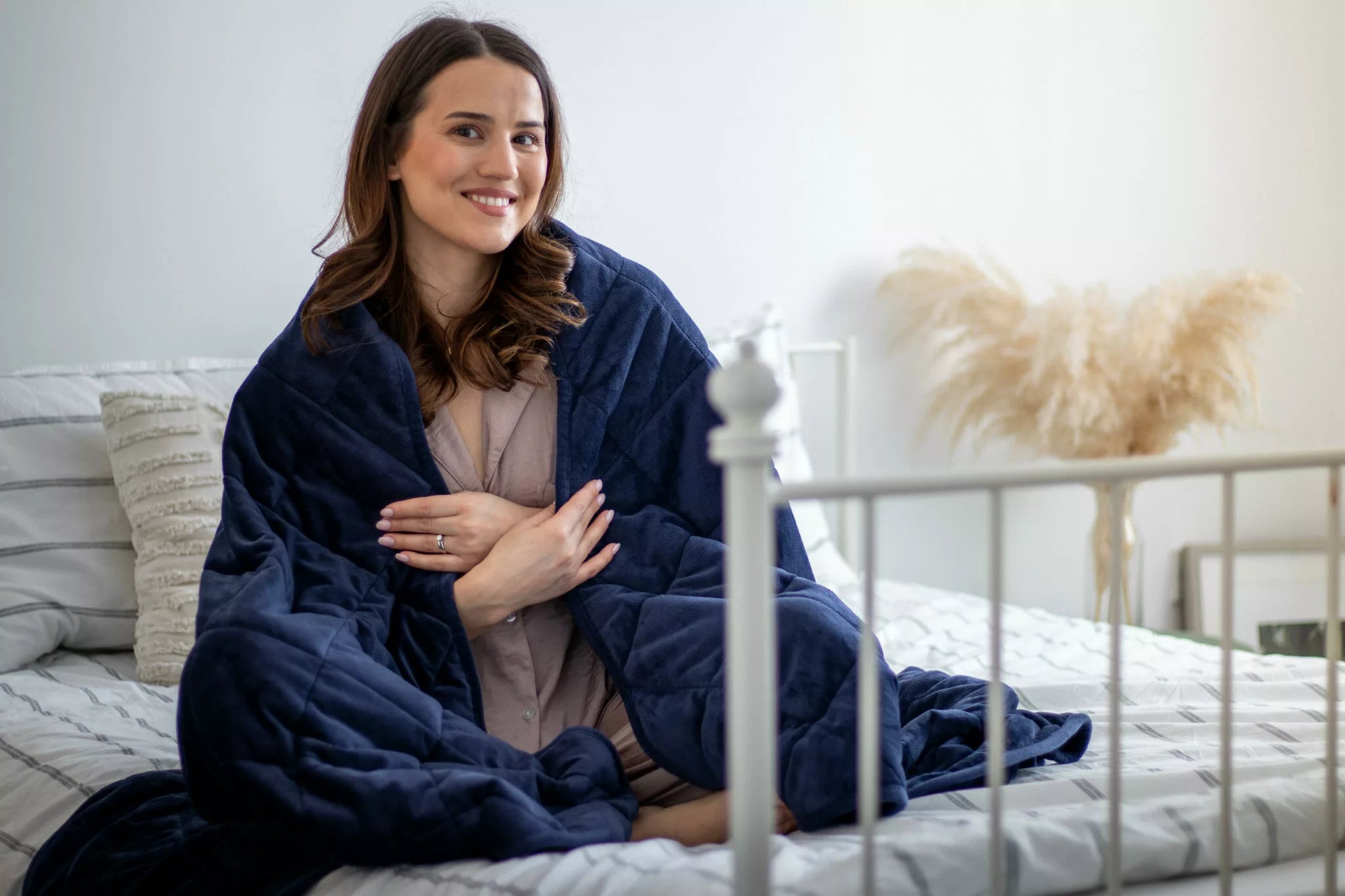 Woman using navy weighted blanket on bed