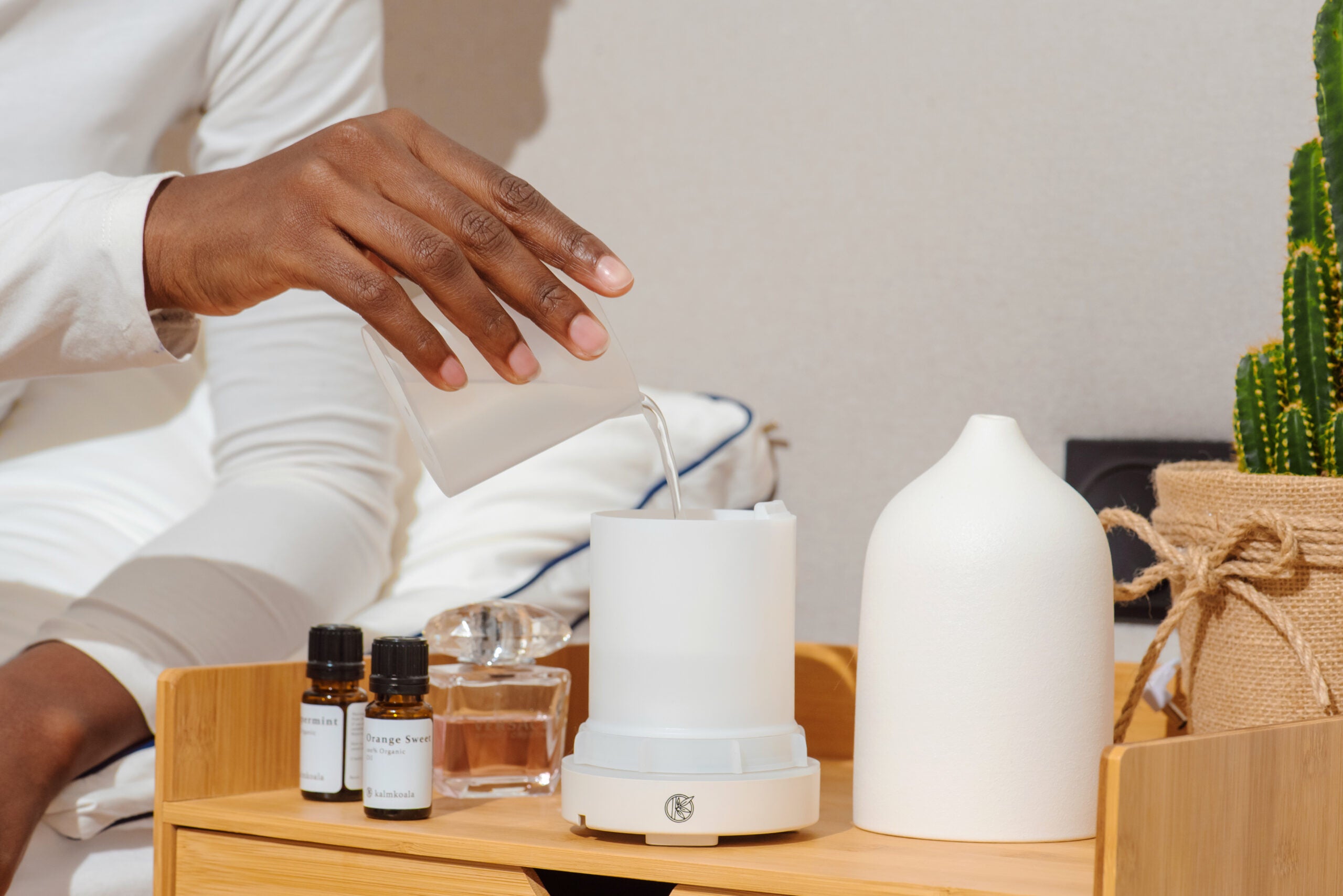 Woman using aromatherapy diffuser and essential oils 
